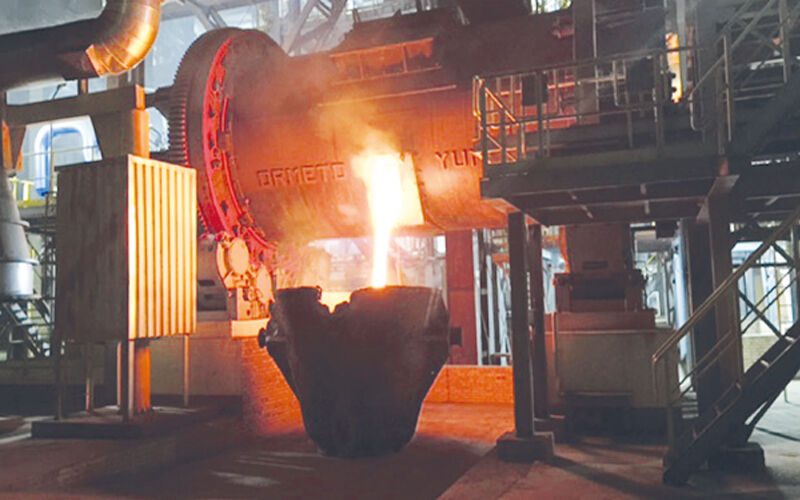 На изображении показан процесс выплавки металла на заводе