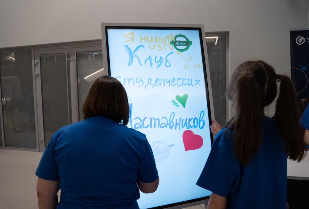 На фотографии участники обучающей программы для будущих наставников возле доски