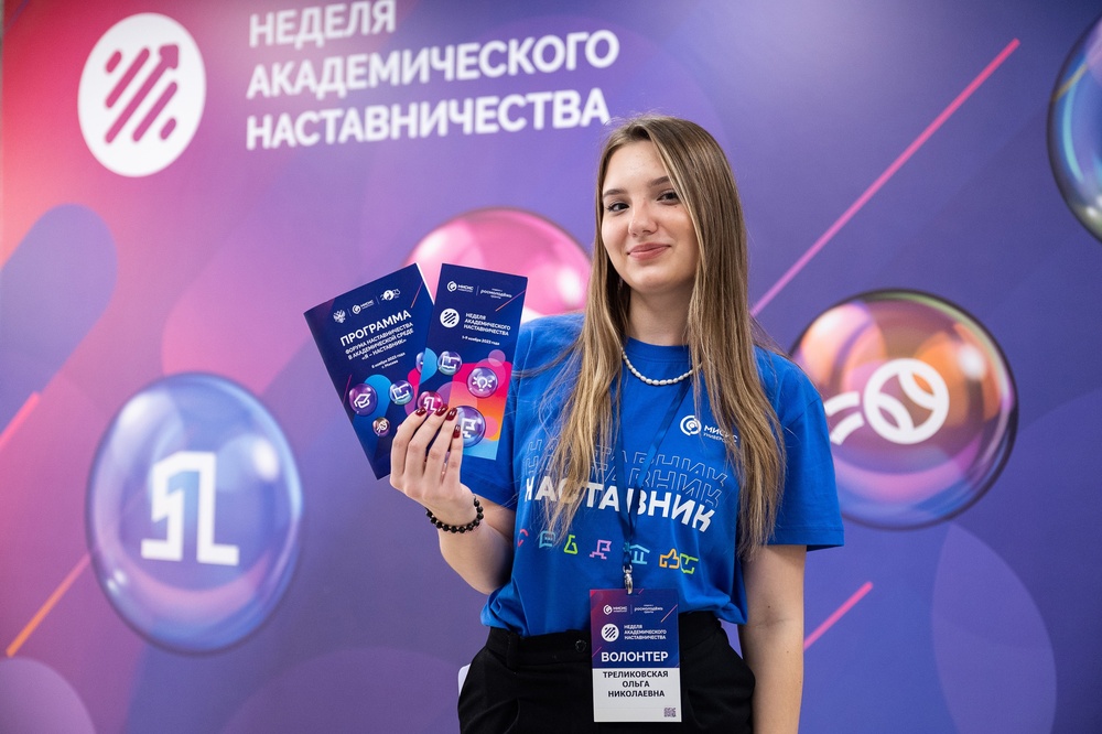 Девушка с брошюрами форума наставничества в академической среде «Я — наставник»