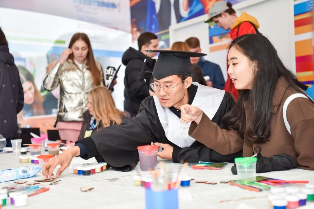На фотографии выпускники рисуют картины